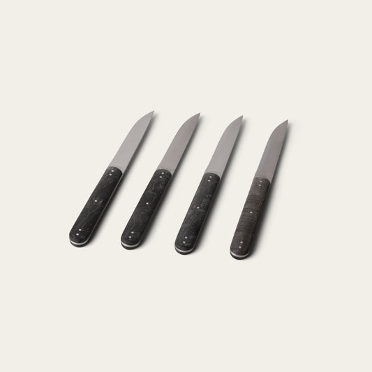Four black-handled knives on a light gray background #black
