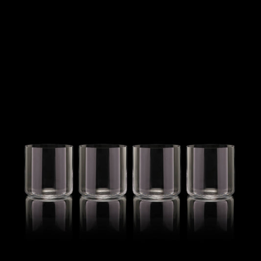 Set of four Fable clear short tumbler glasses on a black background
