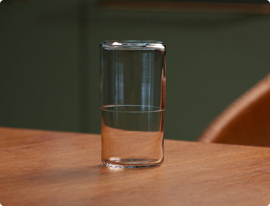 Fable clear double-walled glass tumbler on a wooden table against a dark green background