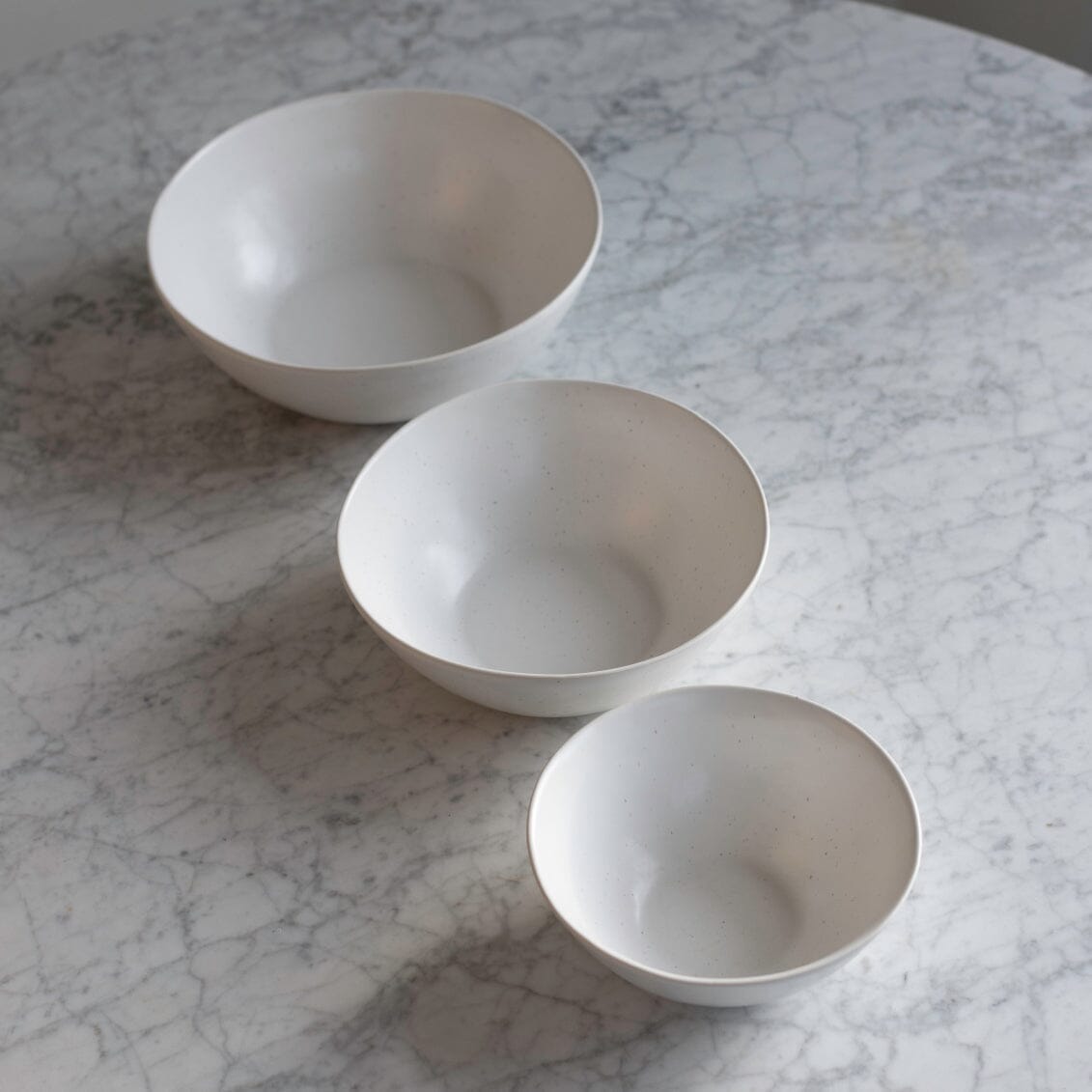 Nested serving bowls dinnerware by Fable Home, shown in a blushpink finish.