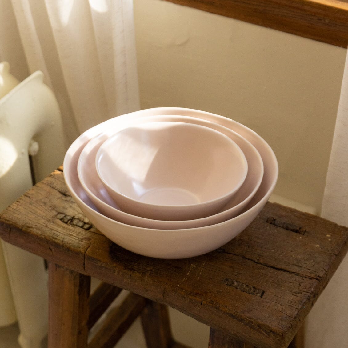 Nested serving bowls dinnerware by Fable Home, shown in a blushpink finish.