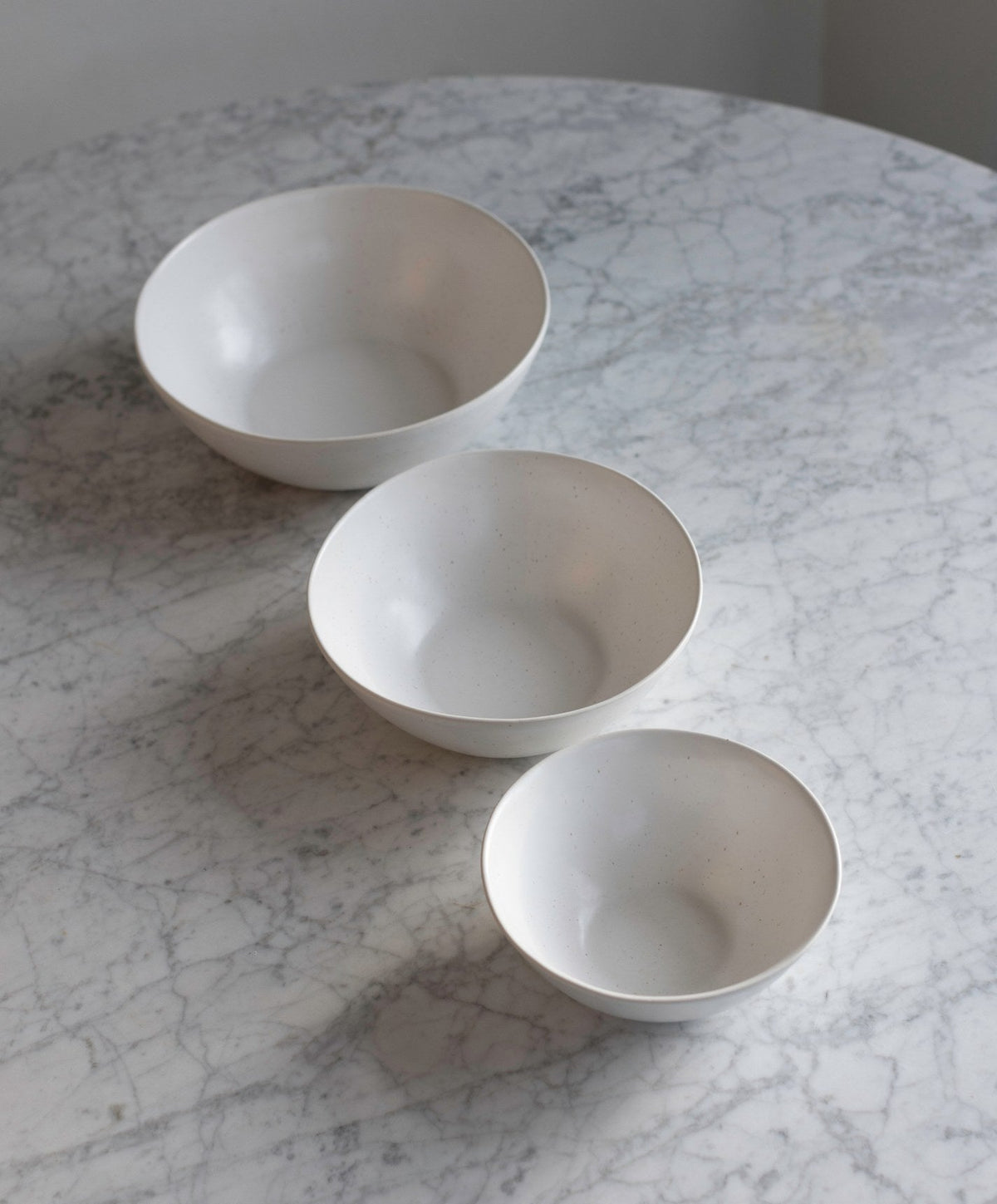 Nested Serving Bowls by Fable Home, shown in Pearl White and Midnight Blue.