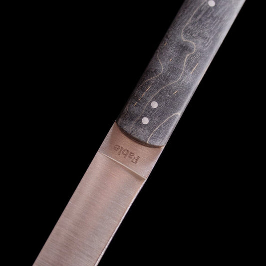 Close-up of a knife blade with a branded handle on a black background #black